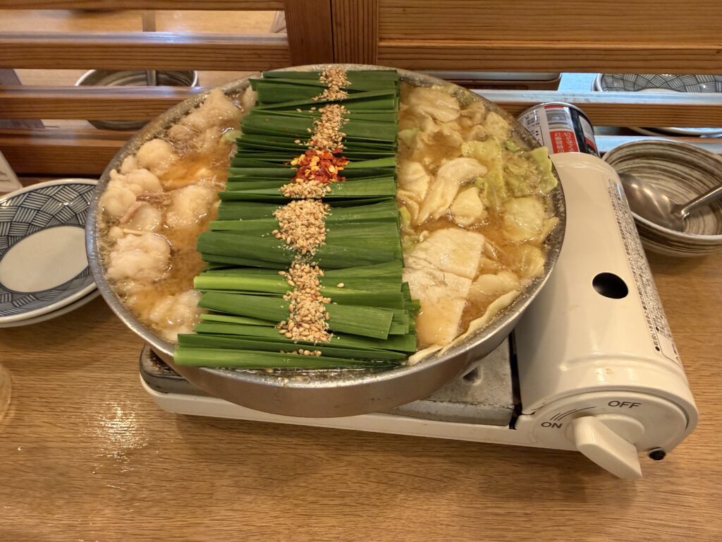 博多もつ鍋 前田屋 総本店で味わう王道の味噌もつ鍋。もつ・キャベツ・ニラに加えてこんにゃくが入った具沢山の鍋で、濃厚な味噌スープの甘みとプリプリしたもつの食感が楽しめる博多名物グルメ