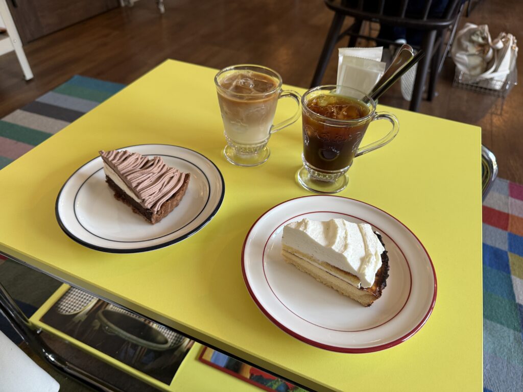 土曜昼の博多駅徒歩圏にある人気カフェの店内風景で、空いた席とおしゃれな内装が見える落ち着いた雰囲気のスナップ。もつ鍋・豚骨ラーメン巡りの合間に立ち寄れる隠れ家カフェの様子