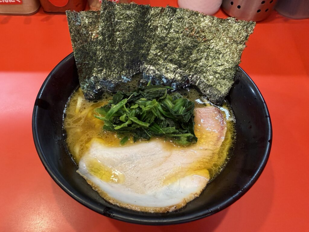 ラーメン内田家で提供される吉村家直系・家系ラーメンの一杯。濃厚な豚骨醤油スープにチャーシュー、ほうれん草、海苔3枚の鉄板トッピングが盛られ、九州唯一の直系店ならではの博多向けにアレンジされた味わいを映す
