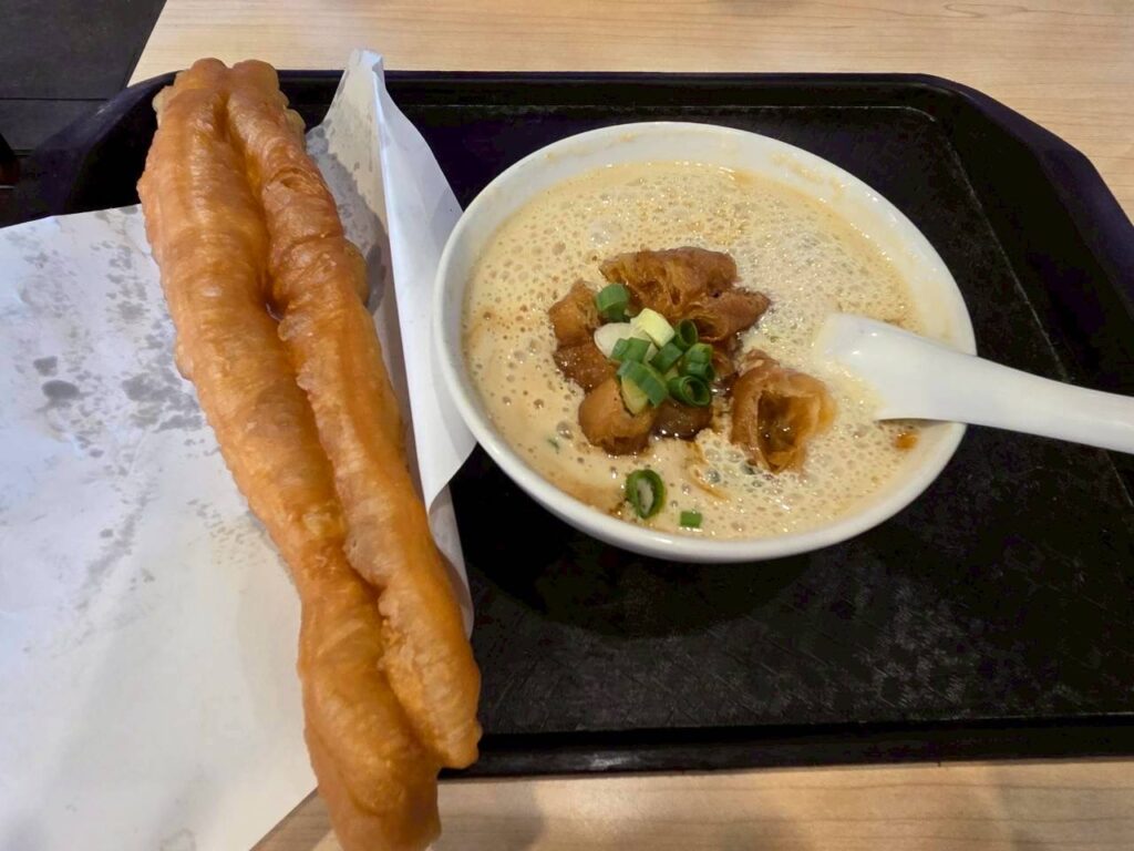 台北の人気朝食店・阜杭豆漿で注文した代表メニューの鹹豆漿(シェン・ドゥジャン)と油條(ヨウティヤオ)をテーブルに並べた様子で、約30分待って入店した台湾旅行初日朝食の素朴な味わいを伝える一枚