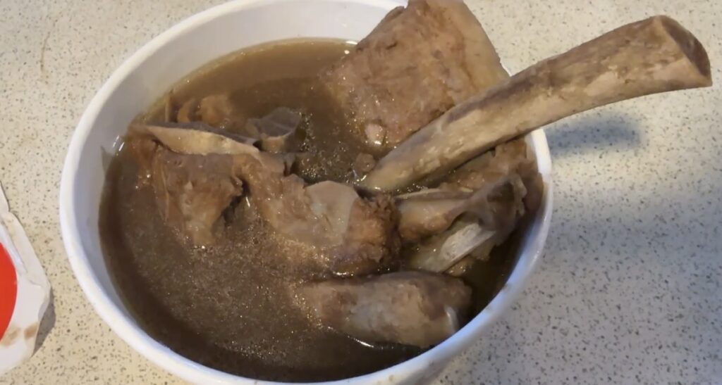 饒河街観光夜市で立ち寄った薬膳スープ専門の屋台を正面から捉えたカットで、骨付き肉や漢方食材が並ぶカウンターと湯気の立つ大鍋が映り、台北夜市ならではの温かみある屋台料理の雰囲気を伝える一枚