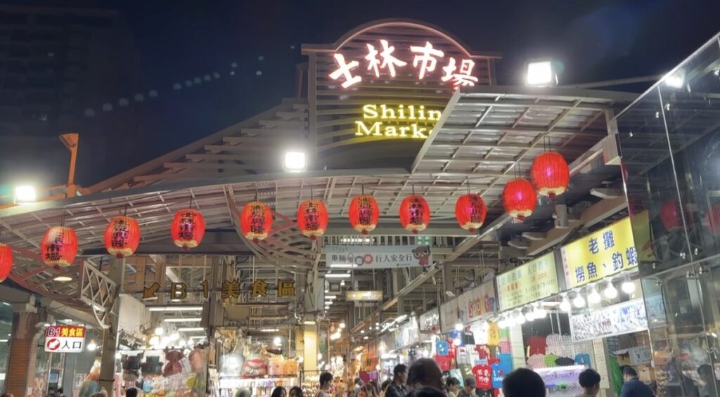台北旅行3日目の夜に訪れた士林夜市の屋台通りの様子。広い範囲にグルメ屋台や射的などのゲーム店が立ち並び、食べ歩きと遊びの両方を楽しめる夜市らしい賑わいが伝わる風景