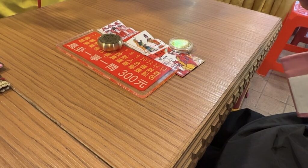 占い師が日本語を話せないかわりに電話で日本語通訳の方に繋ぎ、通訳を介して鳥占いの結果を聞いている体験中の様子
